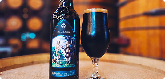 bottle of The Lost Abbey Serpent Kiss with glass